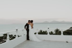 bride and groom hugging overlooking a Tasmanian water scene