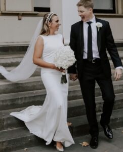 Bride and groom walking down the stairs smiling at each other